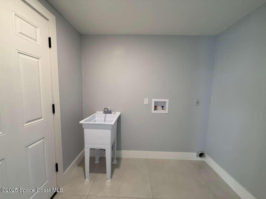1911 Academy Street Northeast Palm Bay, FL 32905 - Photo 49 of 65 a bathroom with a sink a table and a window