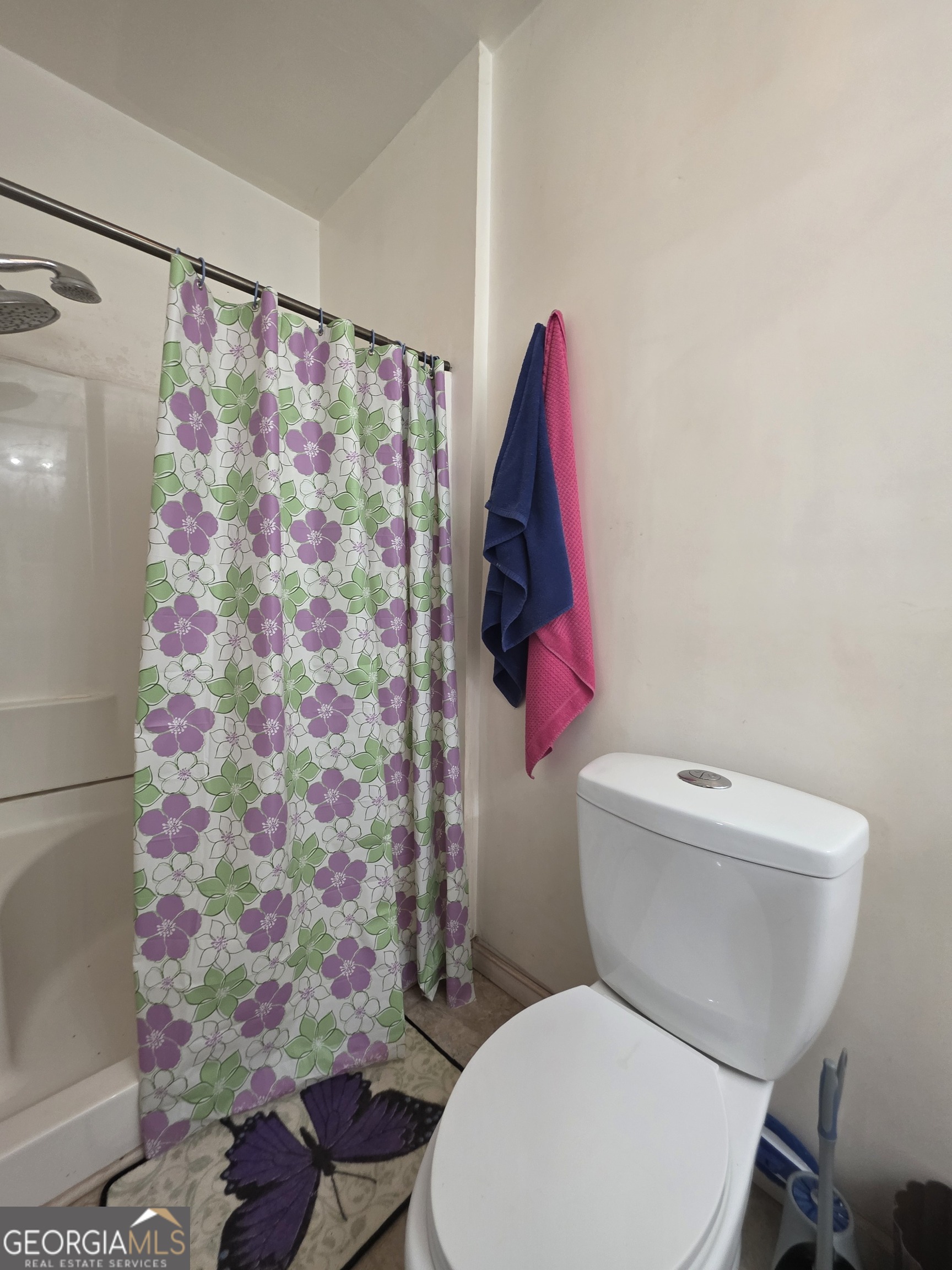 115 Burnside Street Jonesboro, GA 30236 - Photo 19 of 19 a white toilet sitting next to a shower curtain
