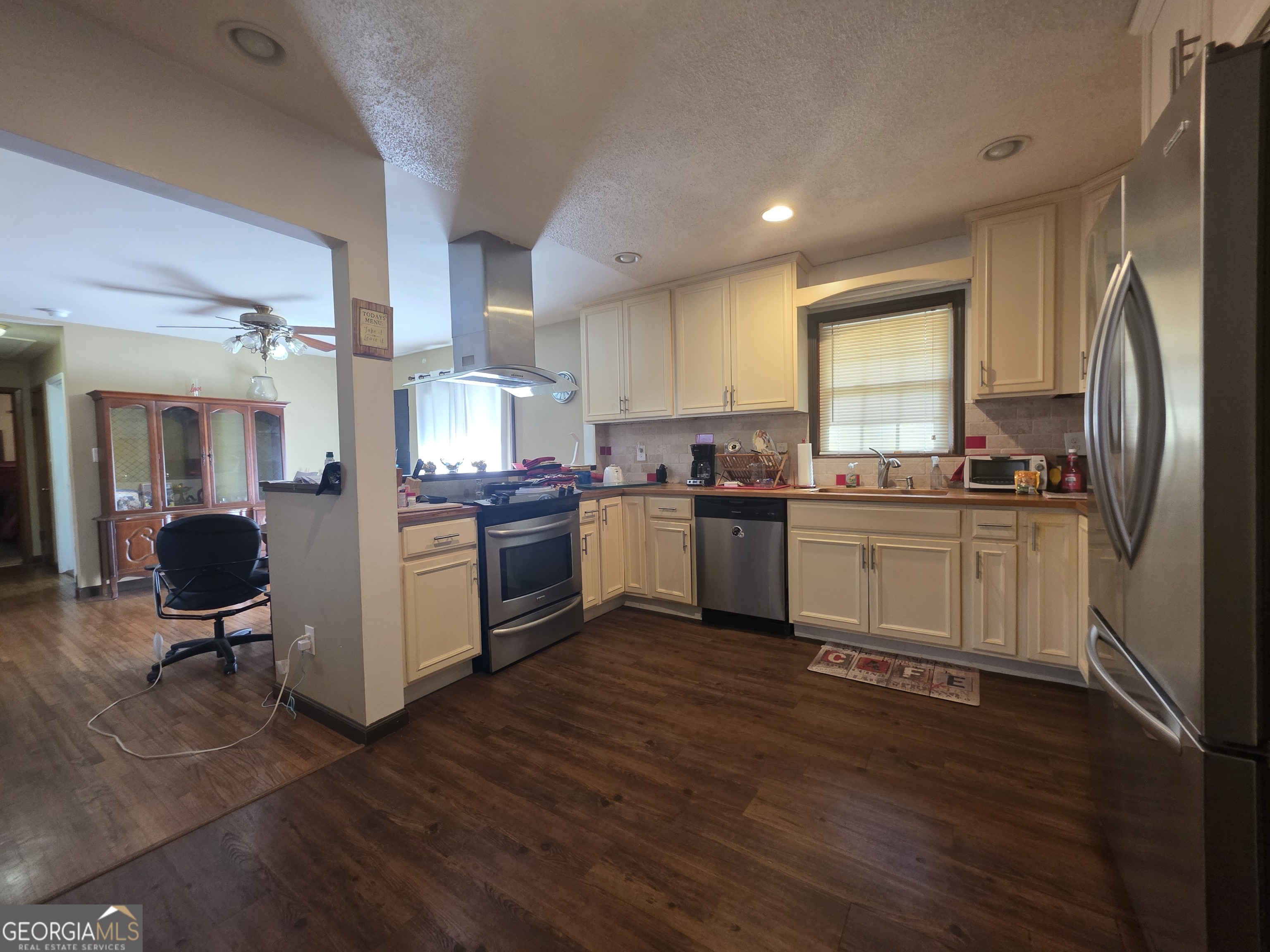 115 Burnside Street Jonesboro, GA 30236 - Photo 5 of 19 a kitchen with stainless steel appliances a stove a sink dishwasher a refrigerator white cabinets and wooden floor