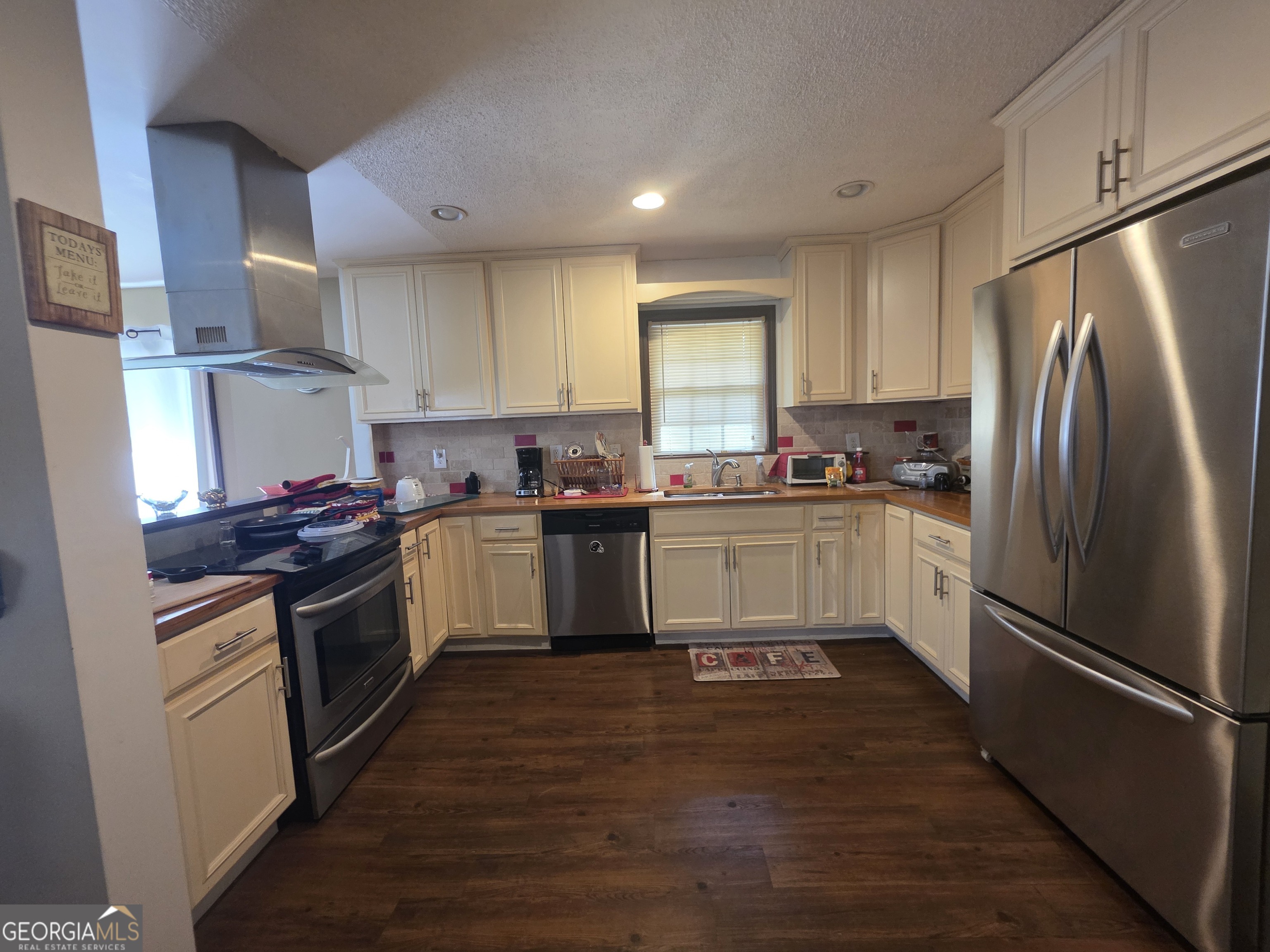 115 Burnside Street Jonesboro, GA 30236 - Photo 6 of 19 a kitchen with a white cabinets a sink a window and stainless steel appliances
