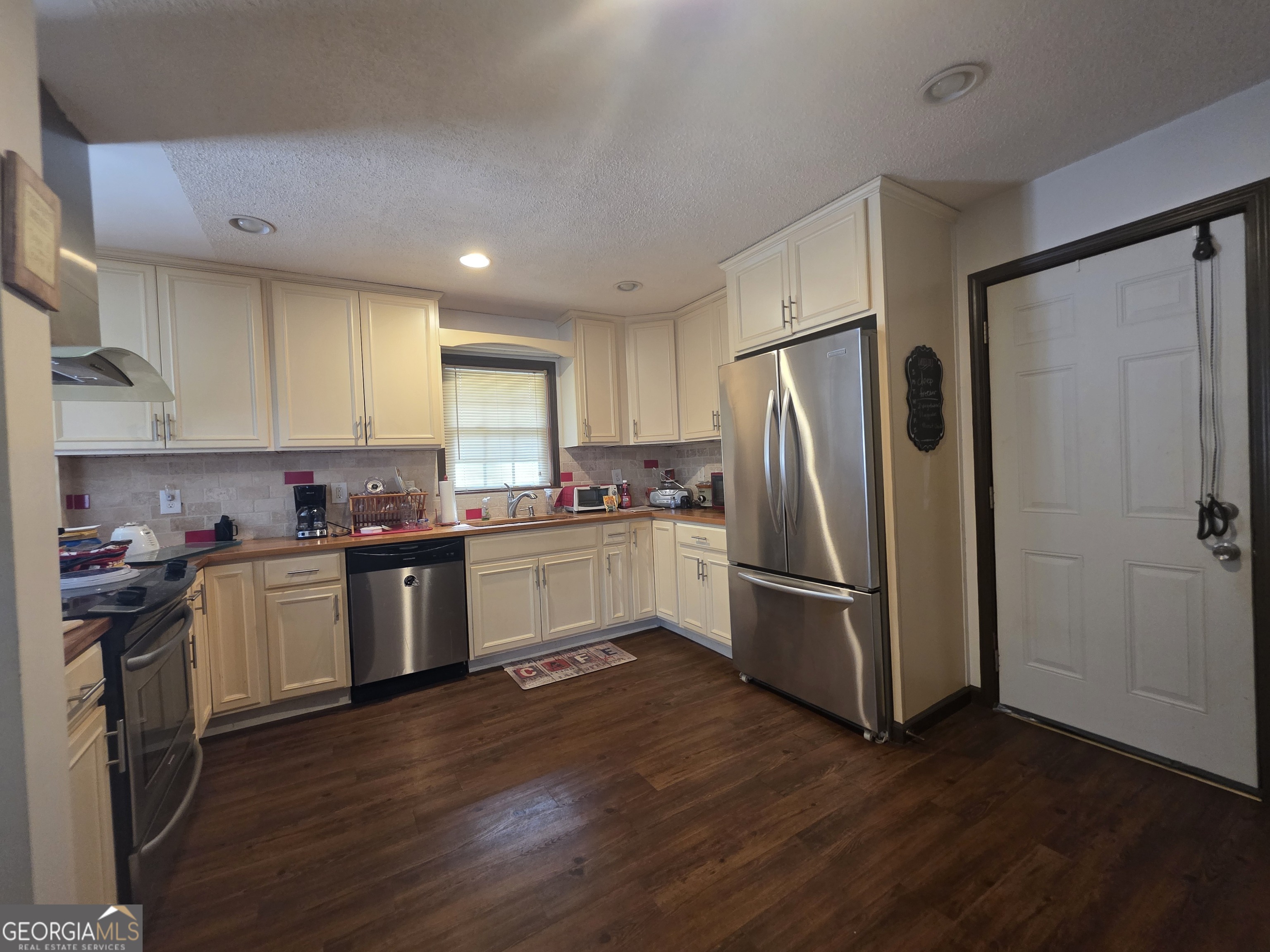 115 Burnside Street Jonesboro, GA 30236 - Photo 7 of 19 a kitchen with a refrigerator cabinets and wooden floor