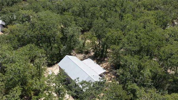 an aerial view of a house with a yard and trees