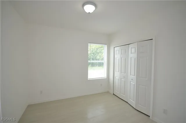 an empty room with windows and closet