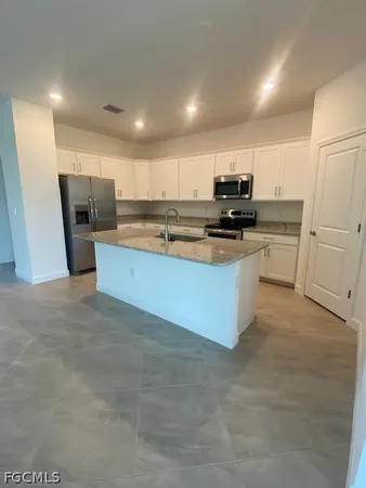 a kitchen with stainless steel appliances granite countertop a stove refrigerator and a sink