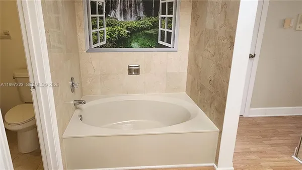 a spacious bathroom with a double vanity sink a mirror and a bathtub