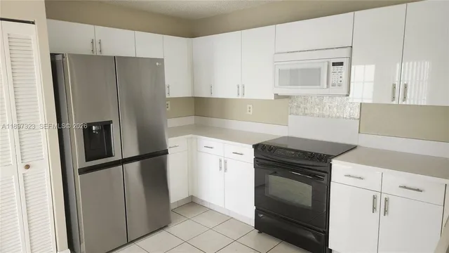 a kitchen with granite countertop white cabinets and white appliances