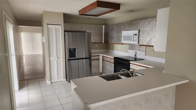 a kitchen with stainless steel appliances granite countertop a refrigerator and a sink