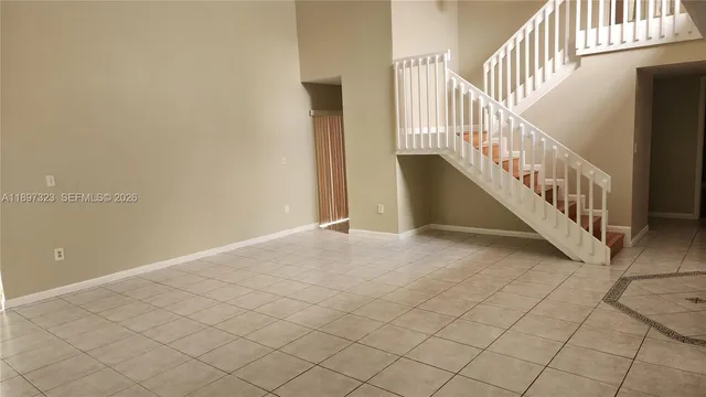 a view of staircase with railing and white walls