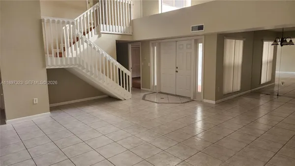 an empty room with wooden floor and cabinet