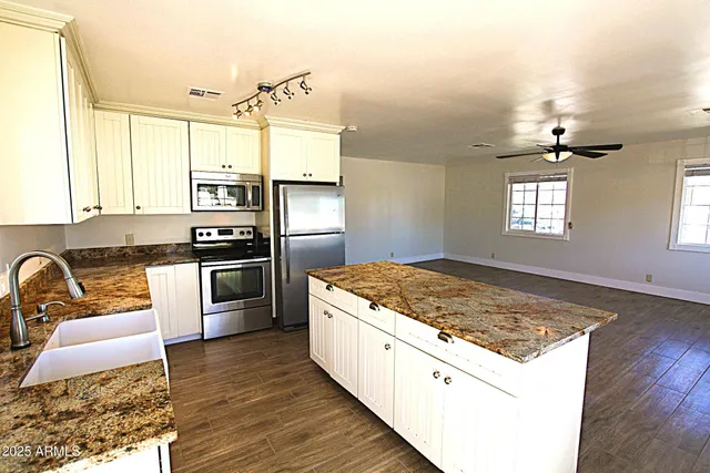 a kitchen with a hardwood floor and window
