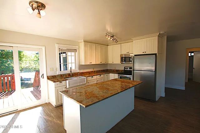 a large kitchen with a wooden floor and a window