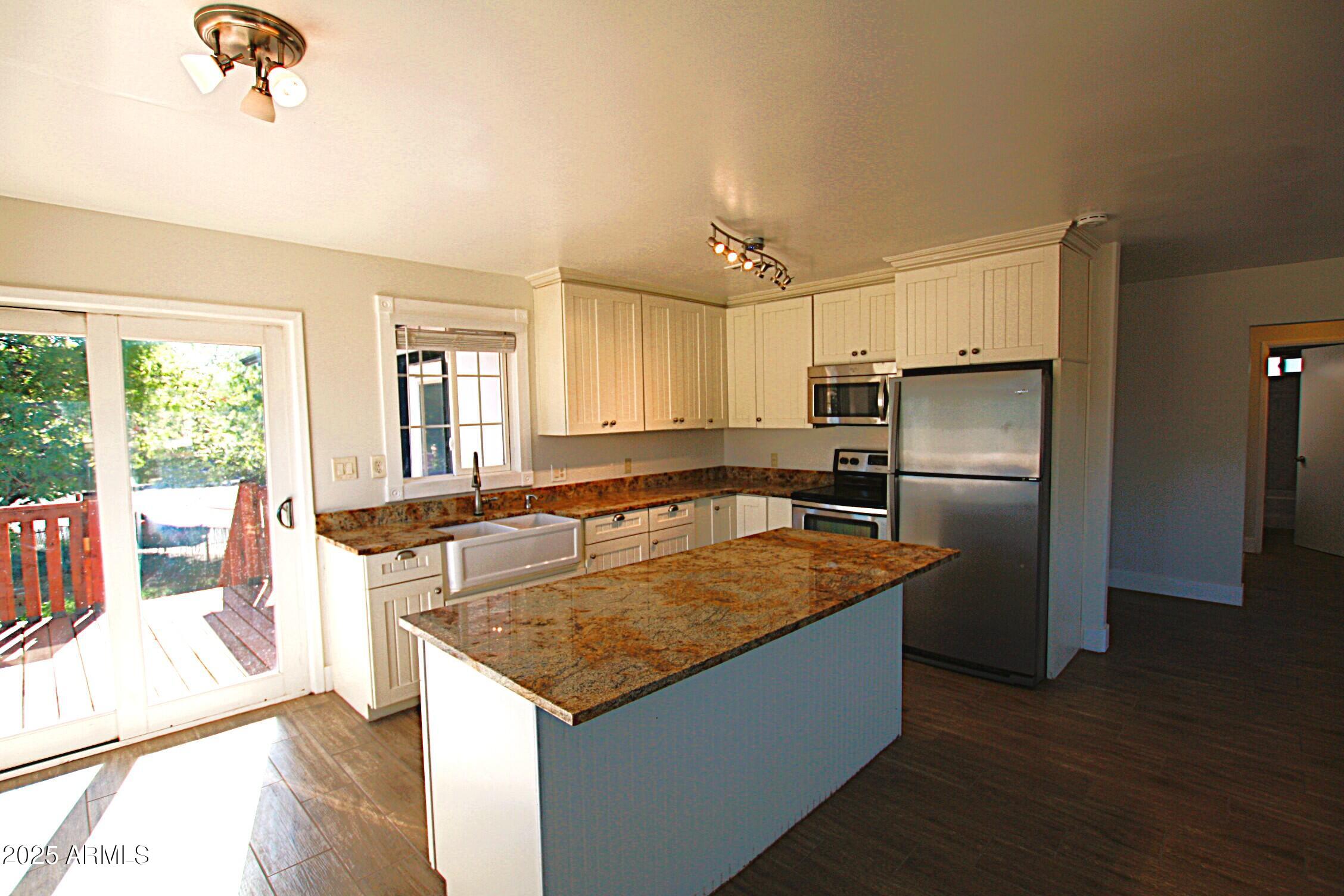 1333 East Flower Street, Unit REAR Phoenix, AZ 85014 - Photo 13 of 34 a kitchen with stainless steel appliances granite countertop a refrigerator a sink and a stove