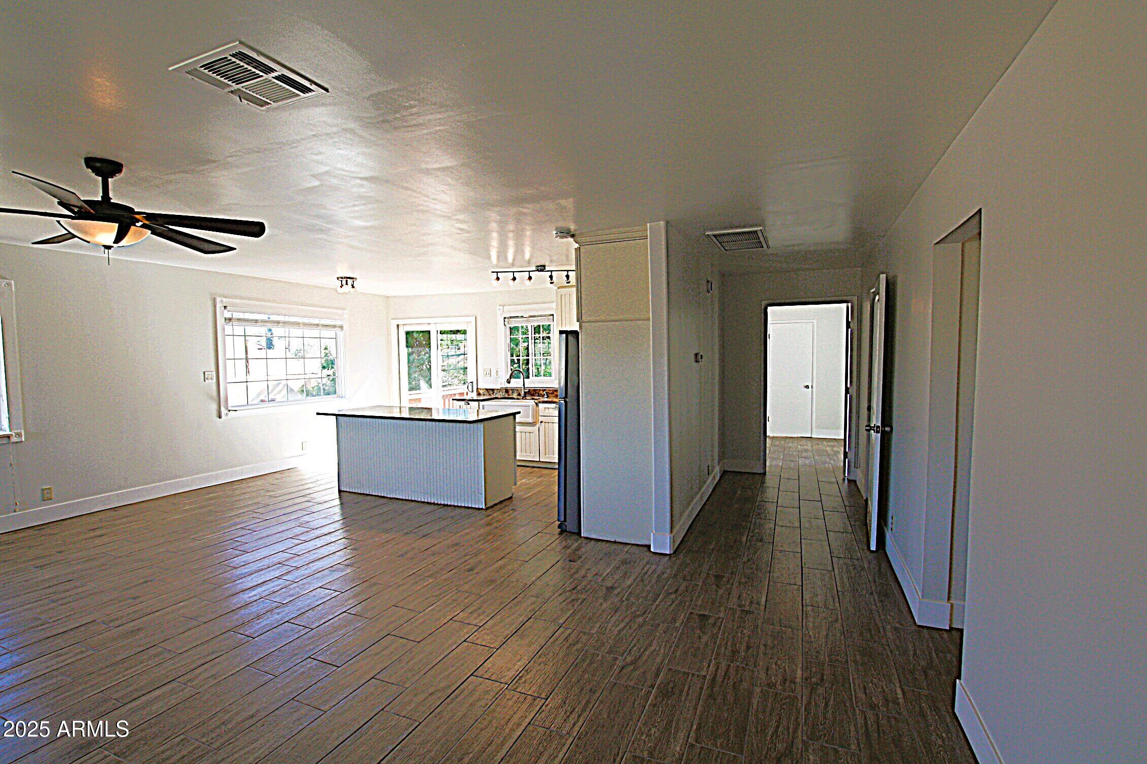 1333 East Flower Street, Unit REAR Phoenix, AZ 85014 - Photo 16 of 34 a view of a kitchen with wooden floor and a ceiling fan