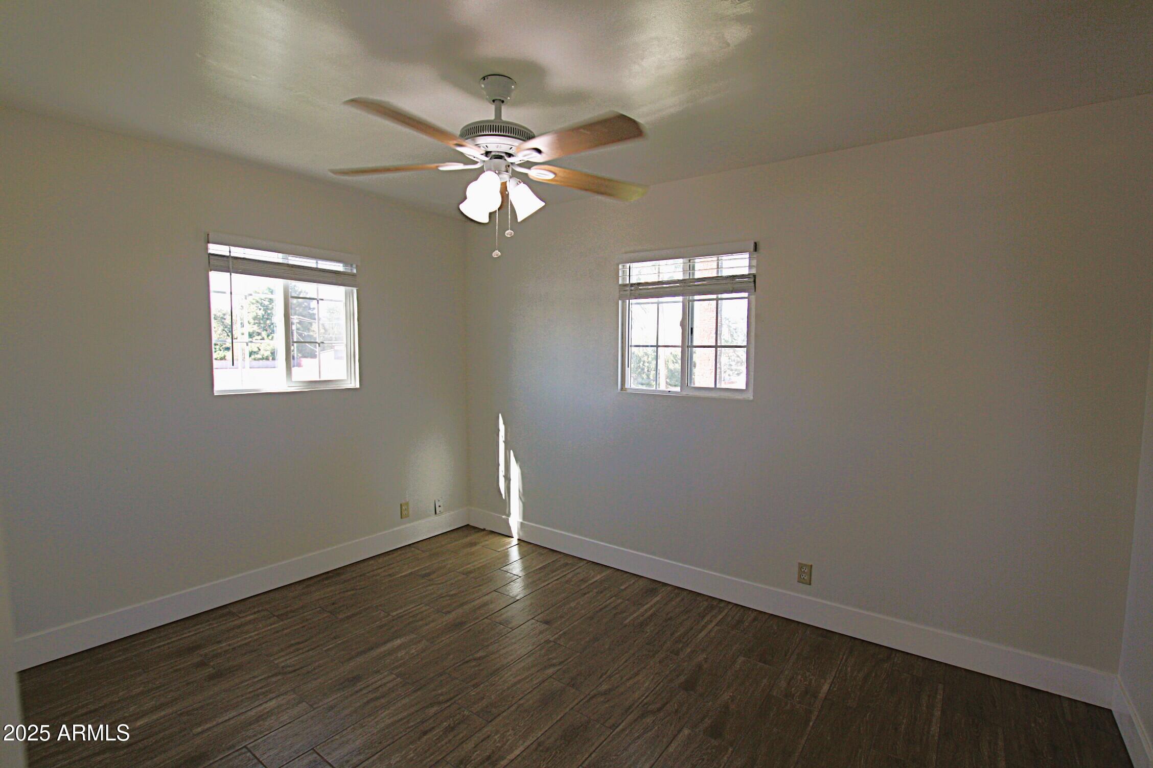 1333 East Flower Street, Unit REAR Phoenix, AZ 85014 - Photo 17 of 34 an empty room with wooden floor and windows