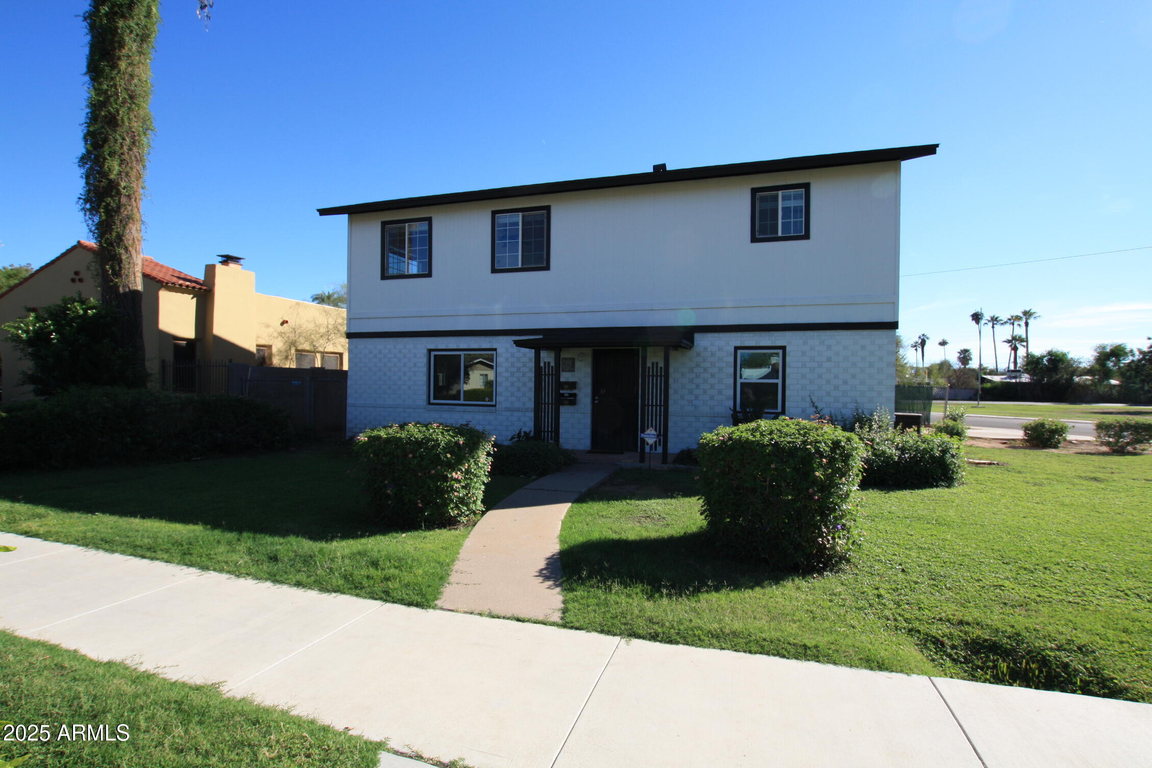 1333 East Flower Street, Unit REAR Phoenix, AZ 85014 - Photo 2 of 34 a front view of a house with a yard and garage