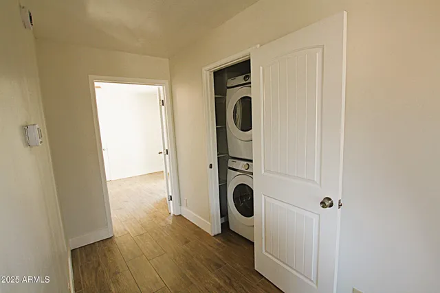 an empty room with wooden floor cabinet and windows