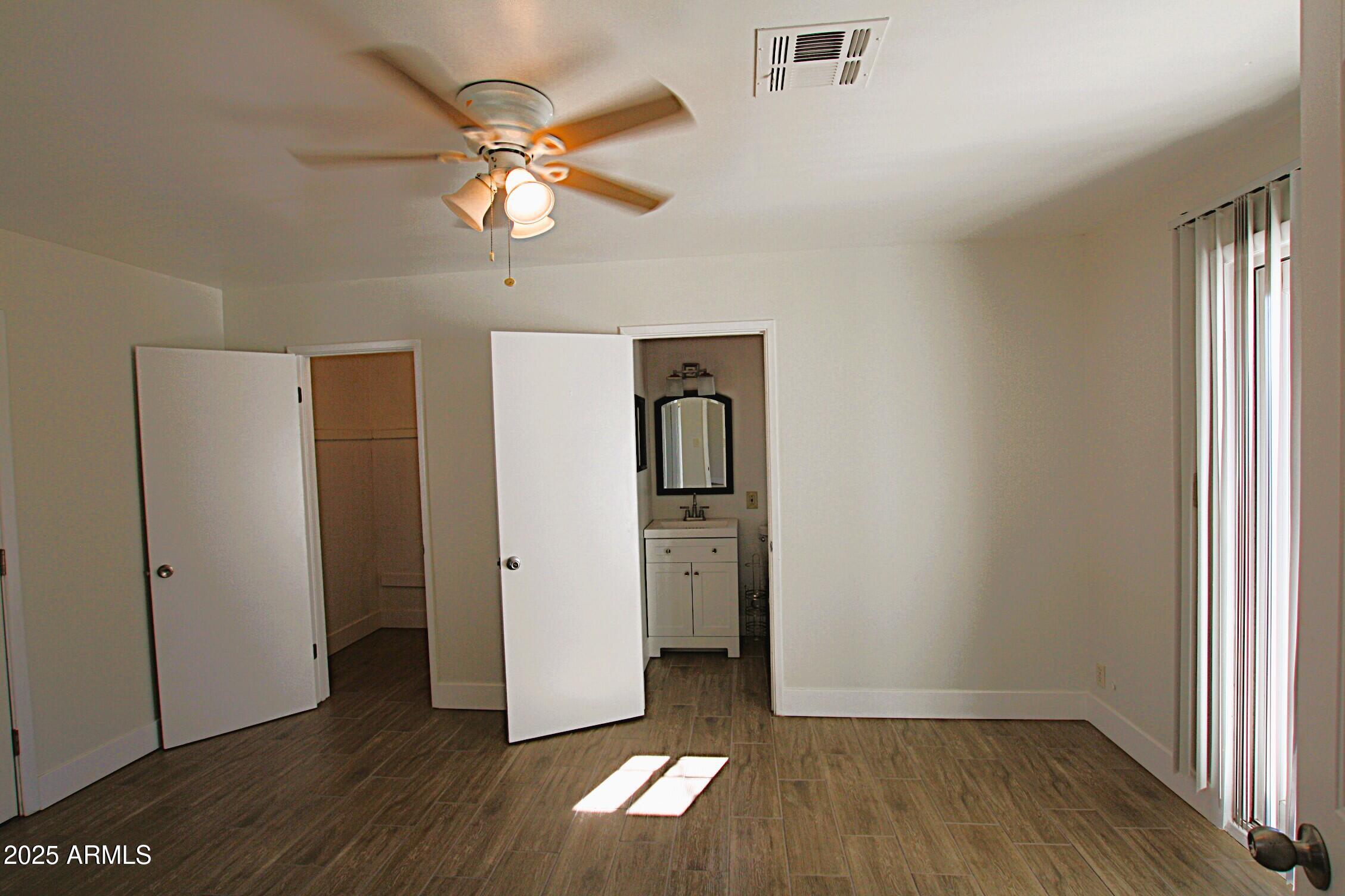 1333 East Flower Street, Unit REAR Phoenix, AZ 85014 - Photo 25 of 34 an empty room with wooden floor cabinet and windows