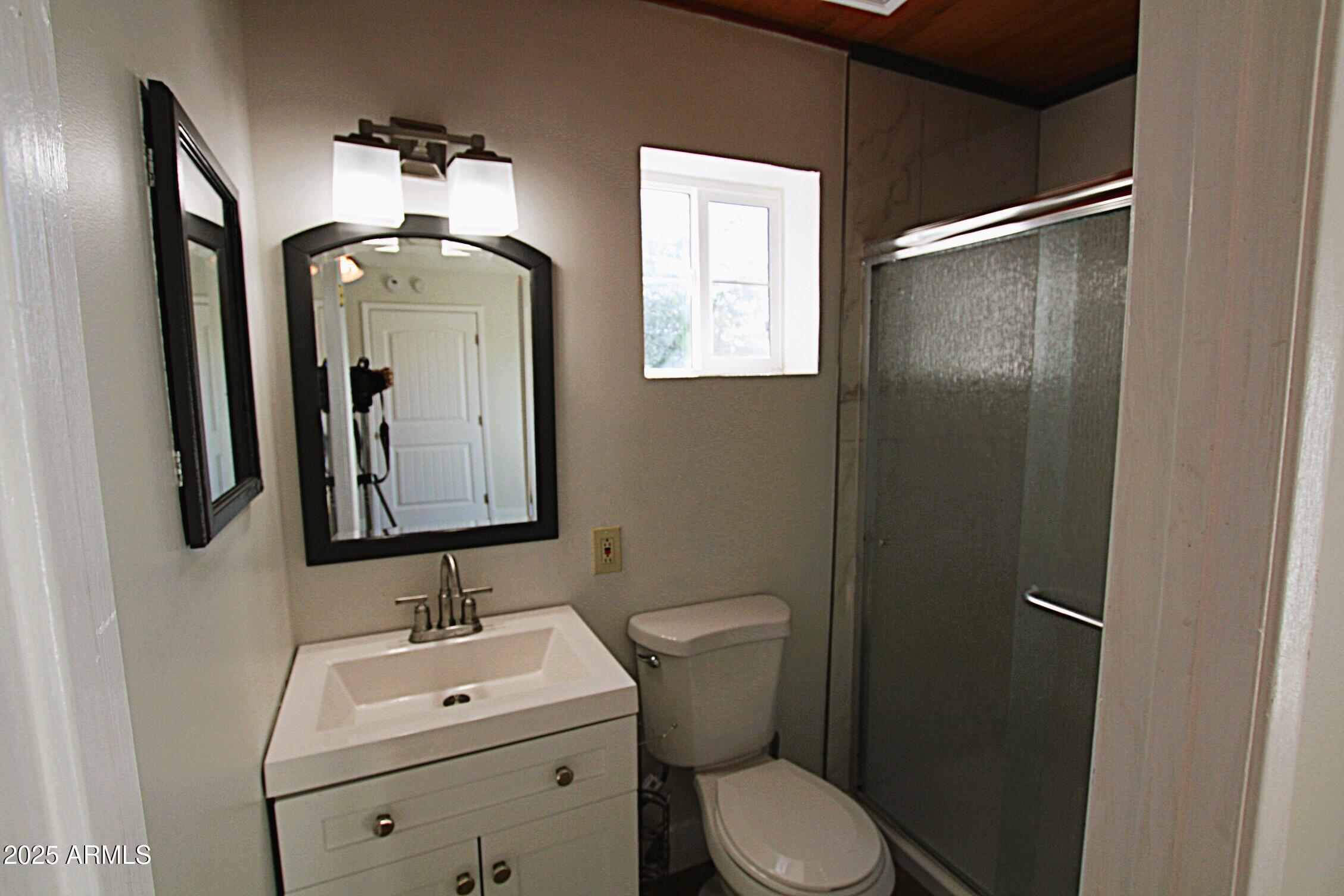 1333 East Flower Street, Unit REAR Phoenix, AZ 85014 - Photo 27 of 34 a bathroom with a toilet sink and mirror