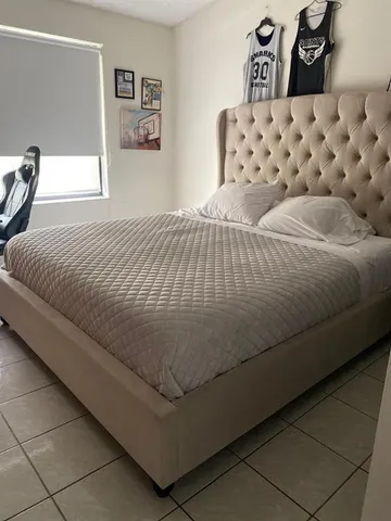 a bed sitting in a bedroom next to a cabinet