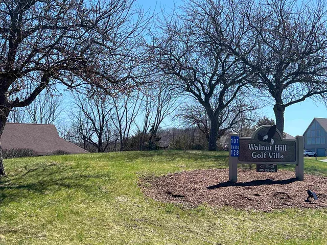 a view of house with a big yard and potted plants and large trees