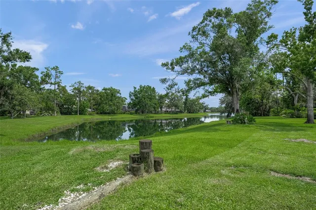 an aerial view of lake residential house with outdoor space and trees all around