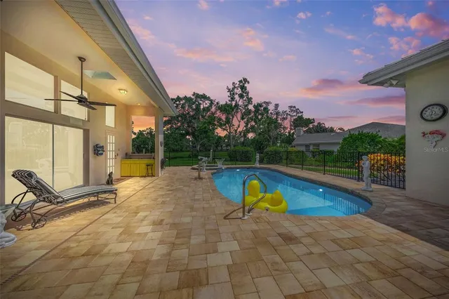 a view of a swimming pool with a lounge chair and a small yard