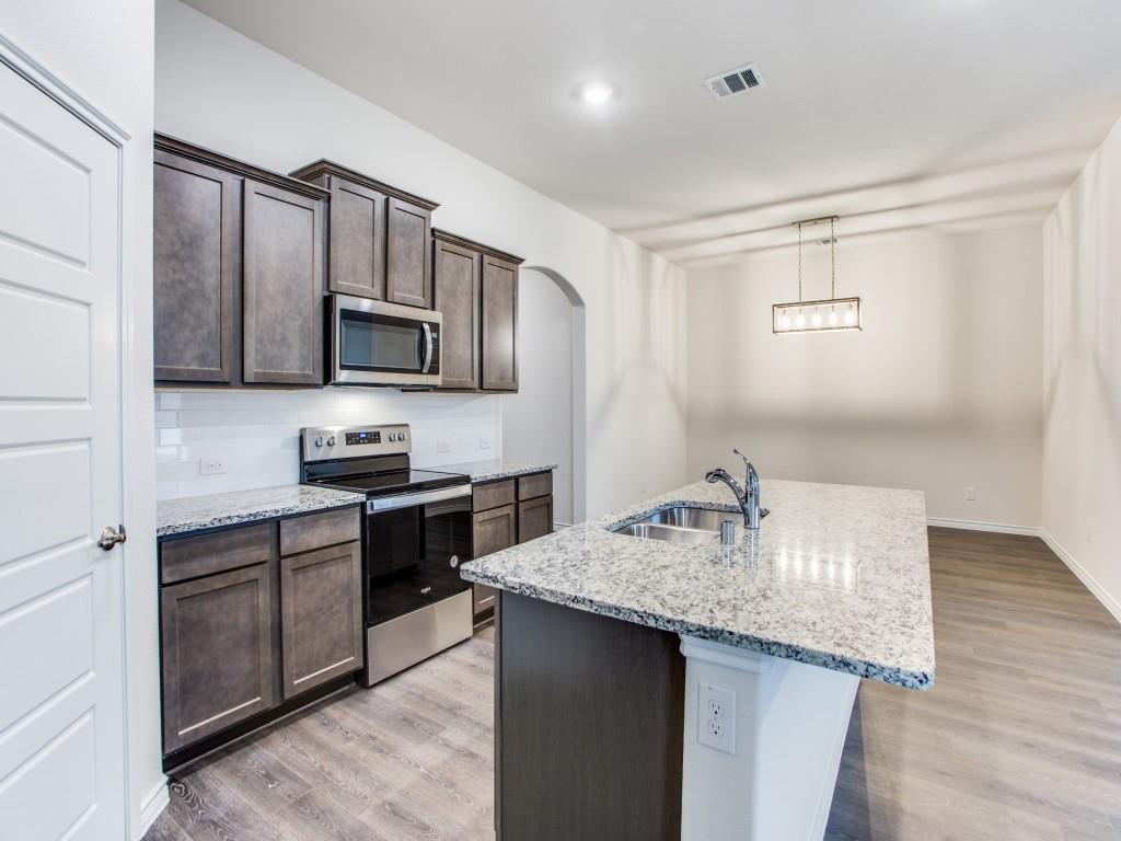 123 Lakeview Circle Pilot Point, TX 76258 - Photo 17 of 39 a kitchen with granite countertop a sink stove and microwave