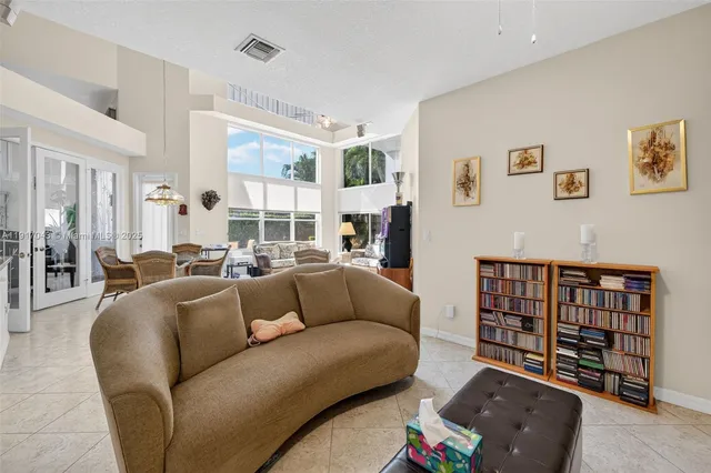 a spacious bedroom with a bed a couch and a chandelier