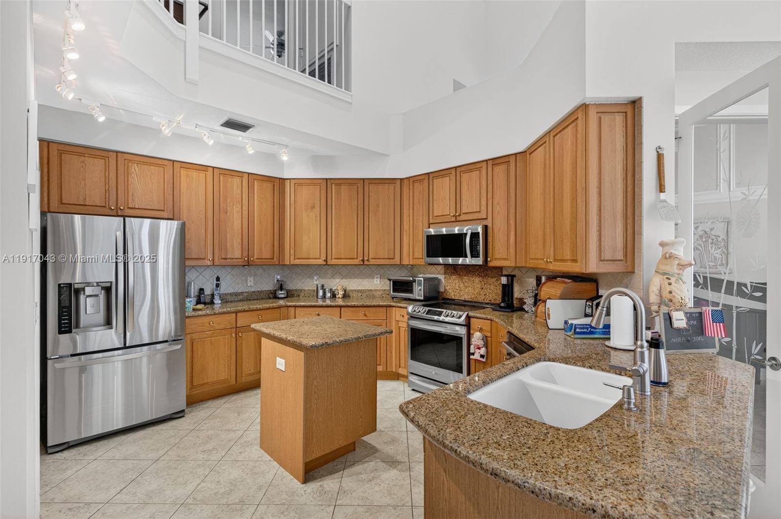 4123 West Lake Estates Drive Davie, FL 33328 - Photo 18 of 56 a kitchen with stainless steel appliances granite countertop a stove a sink a refrigerator and island