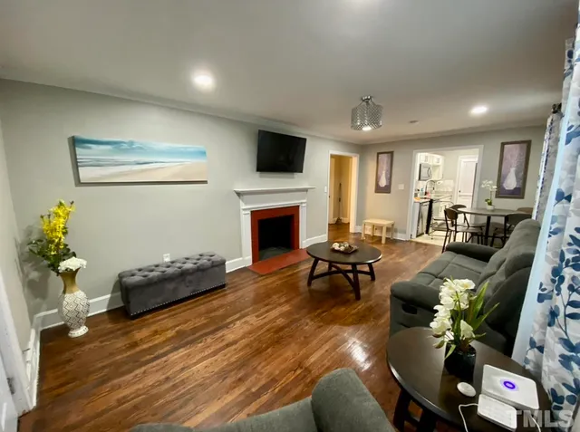 a living room with furniture a flat screen tv and a fireplace