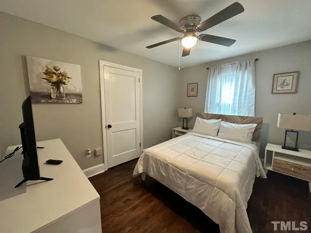 a bedroom with a large bed and a chandelier