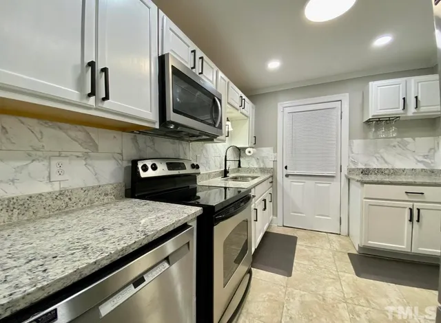 a kitchen with granite countertop stainless steel appliances and sink