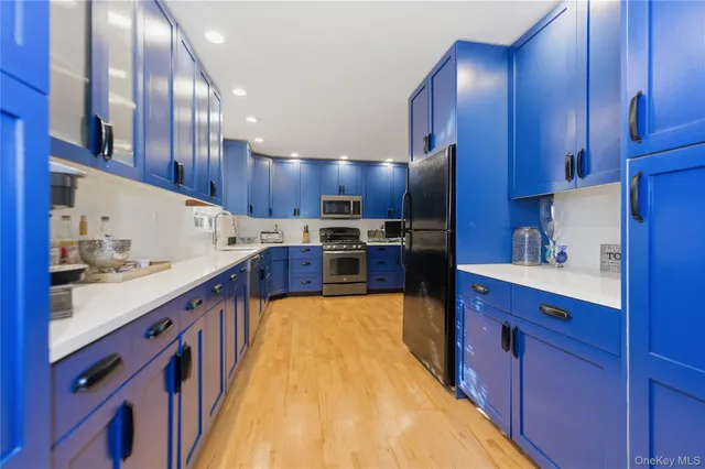 a large kitchen with stainless steel appliances and wooden cabinets