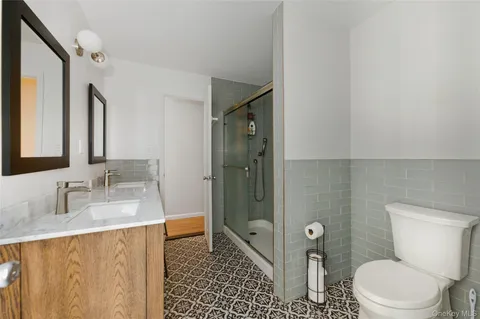 a bathroom with a granite countertop sink toilet and shower