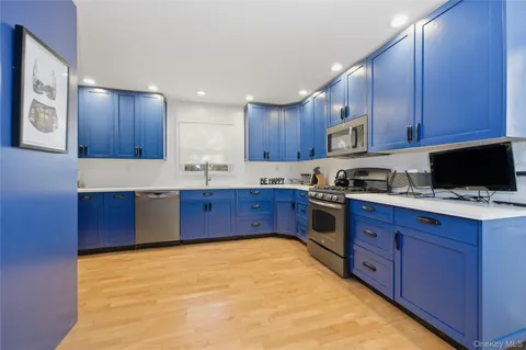 a kitchen with stainless steel appliances granite countertop wooden cabinets a stove top oven a sink and dishwasher