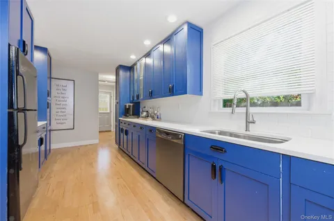 a kitchen with kitchen island granite countertop a sink and wooden cabinets