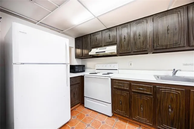 a kitchen with stainless steel appliances granite countertop a refrigerator a sink and a stove