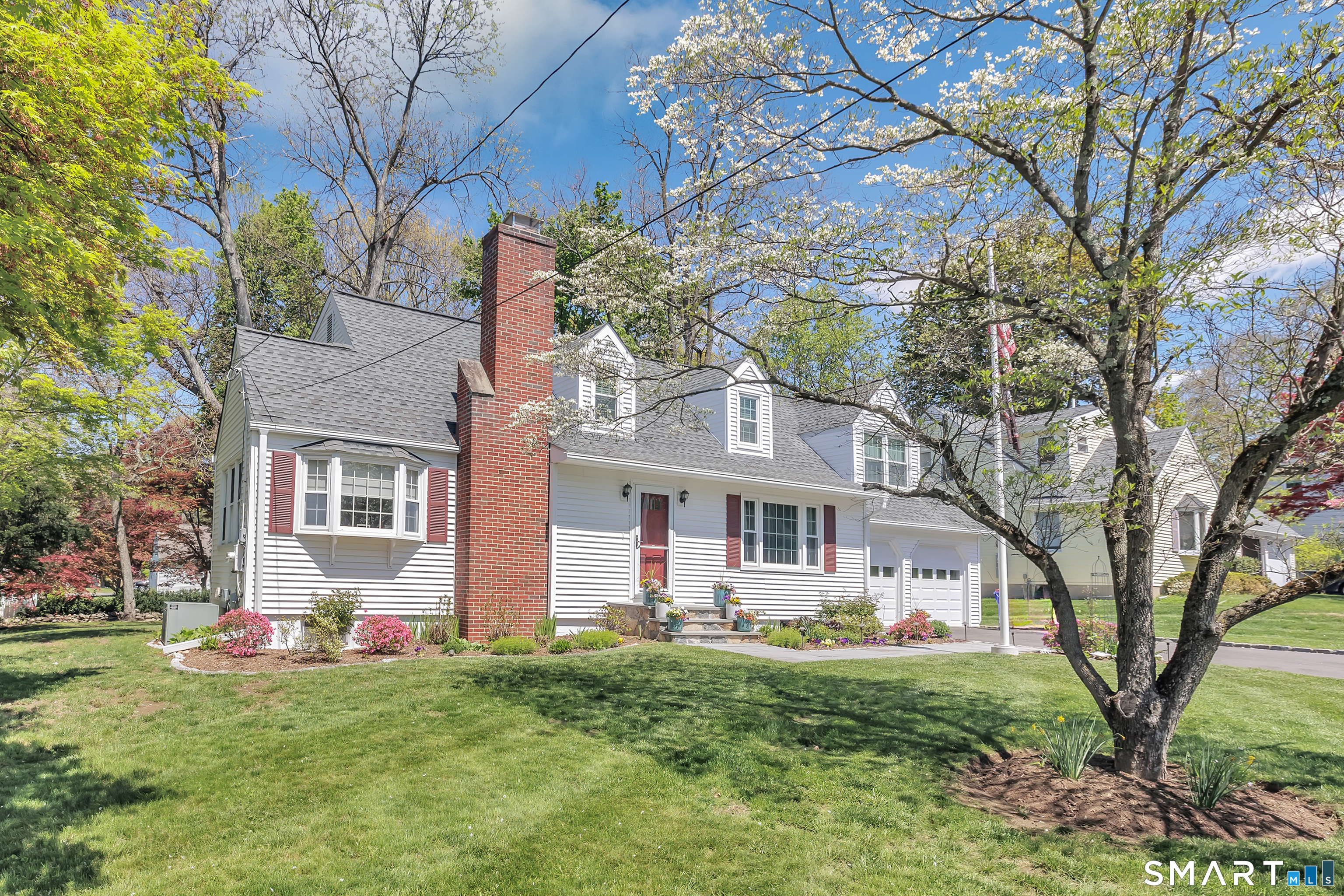 58 Colony Avenue Trumbull, CT 06611 - Photo 3 of 38 a front view of a house with a garden and tree
