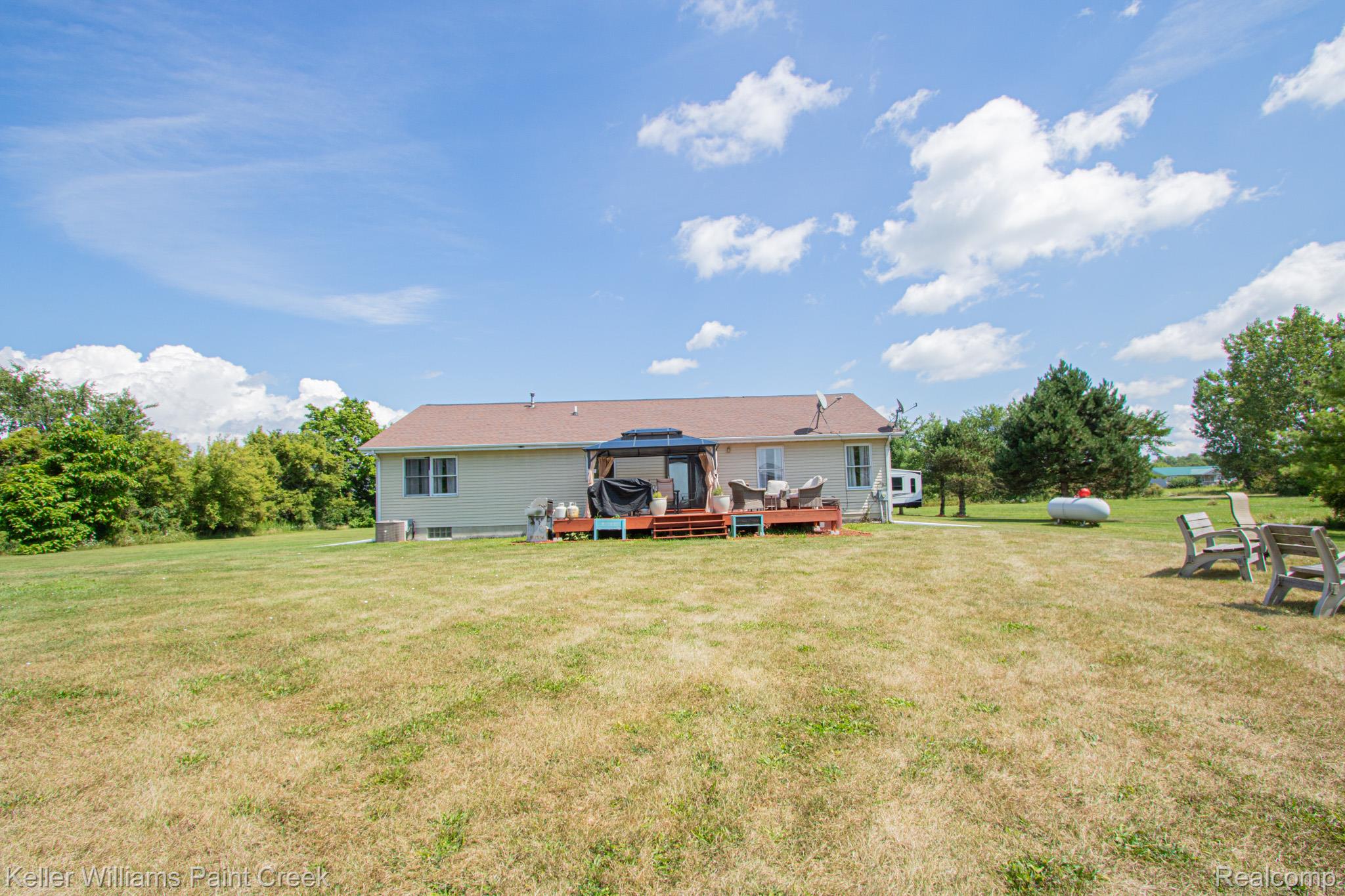 625 Howell Road Allenton, MI 48002 - Photo 42 of 46 Expansive green space with a rear deck and mature trees