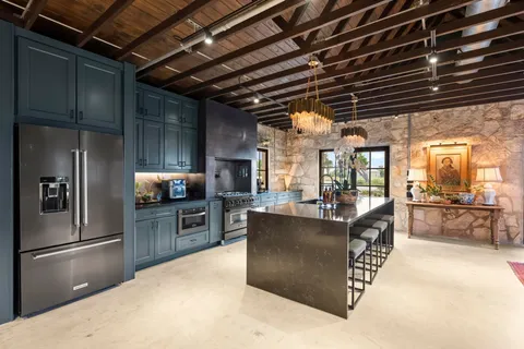 a kitchen with stainless steel appliances granite countertop a sink a stove and a refrigerator