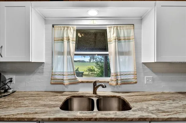 a kitchen with stainless steel appliances a table chairs in it and wooden floors