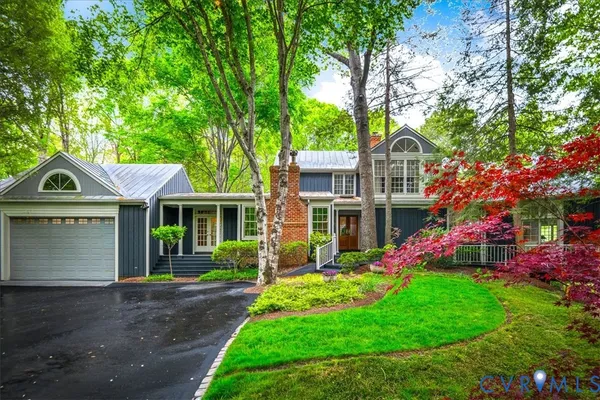 a front view of a house with a yard and trees