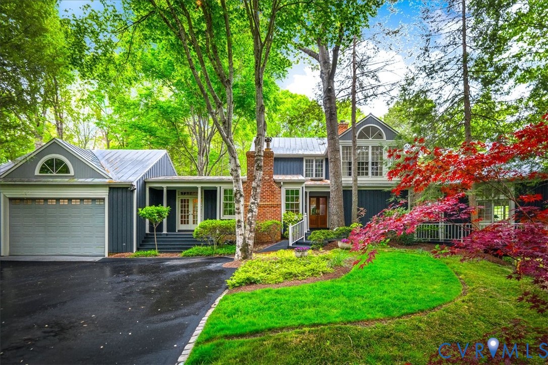 a front view of a house with a yard and trees
