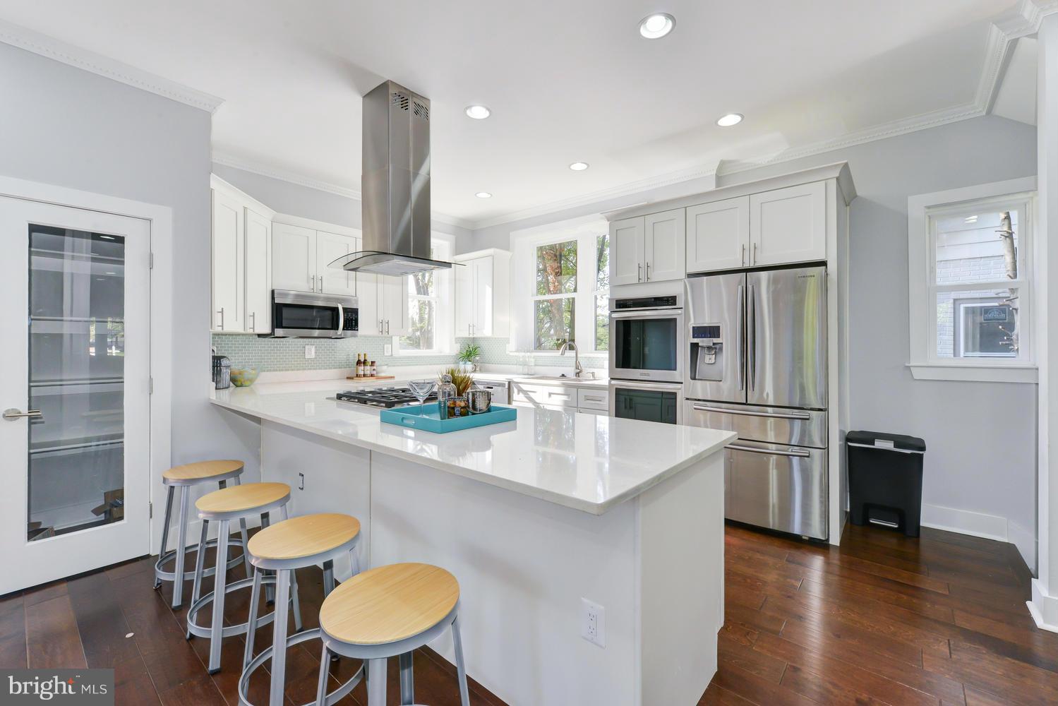 6729 Piney Branch Road Northwest Washington, DC 20012 - Photo 6 of 30 a kitchen with stainless steel appliances a dining table chairs and refrigerator