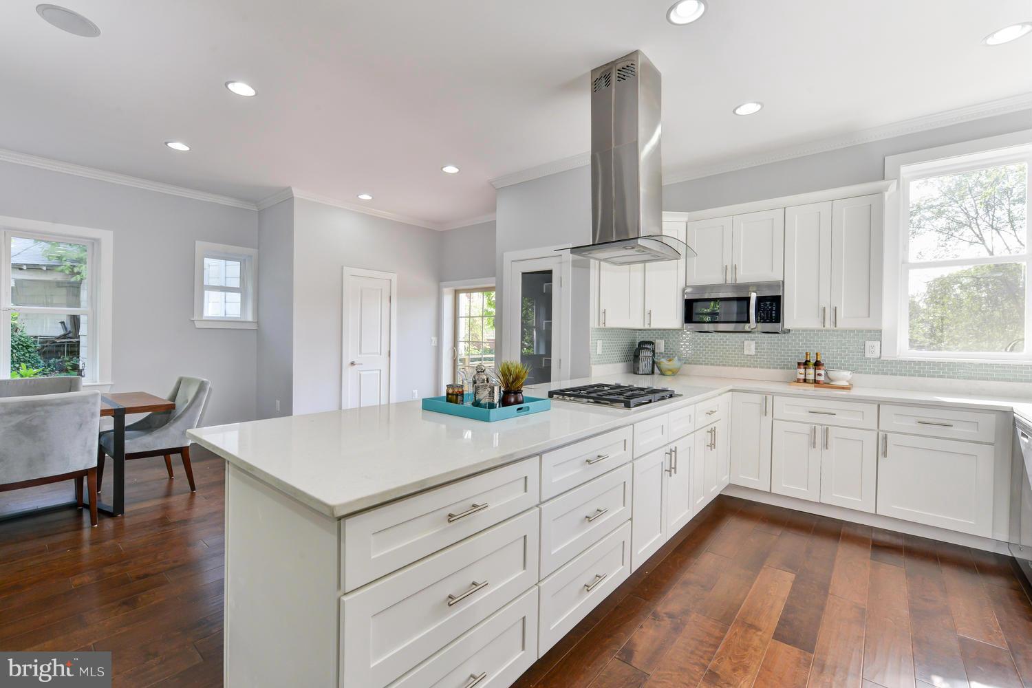 6729 Piney Branch Road Northwest Washington, DC 20012 - Photo 9 of 30 a kitchen with white cabinets appliances and wooden floor