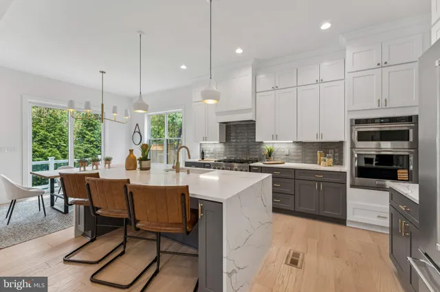 a large kitchen with kitchen island a table and chairs in it