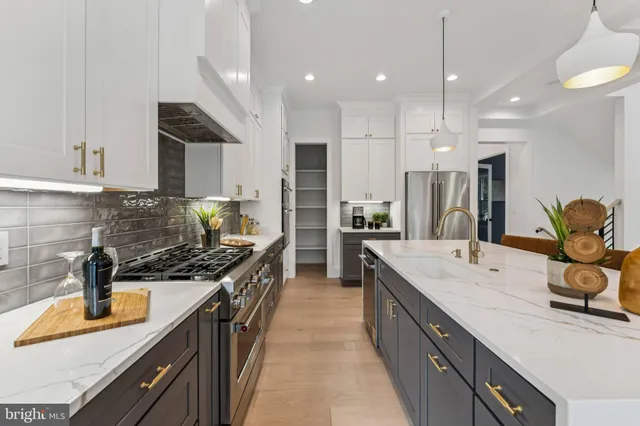 a kitchen with kitchen island granite countertop a sink a counter top space appliances and cabinets