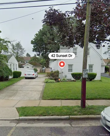 a front view of a house with a garden and parking space
