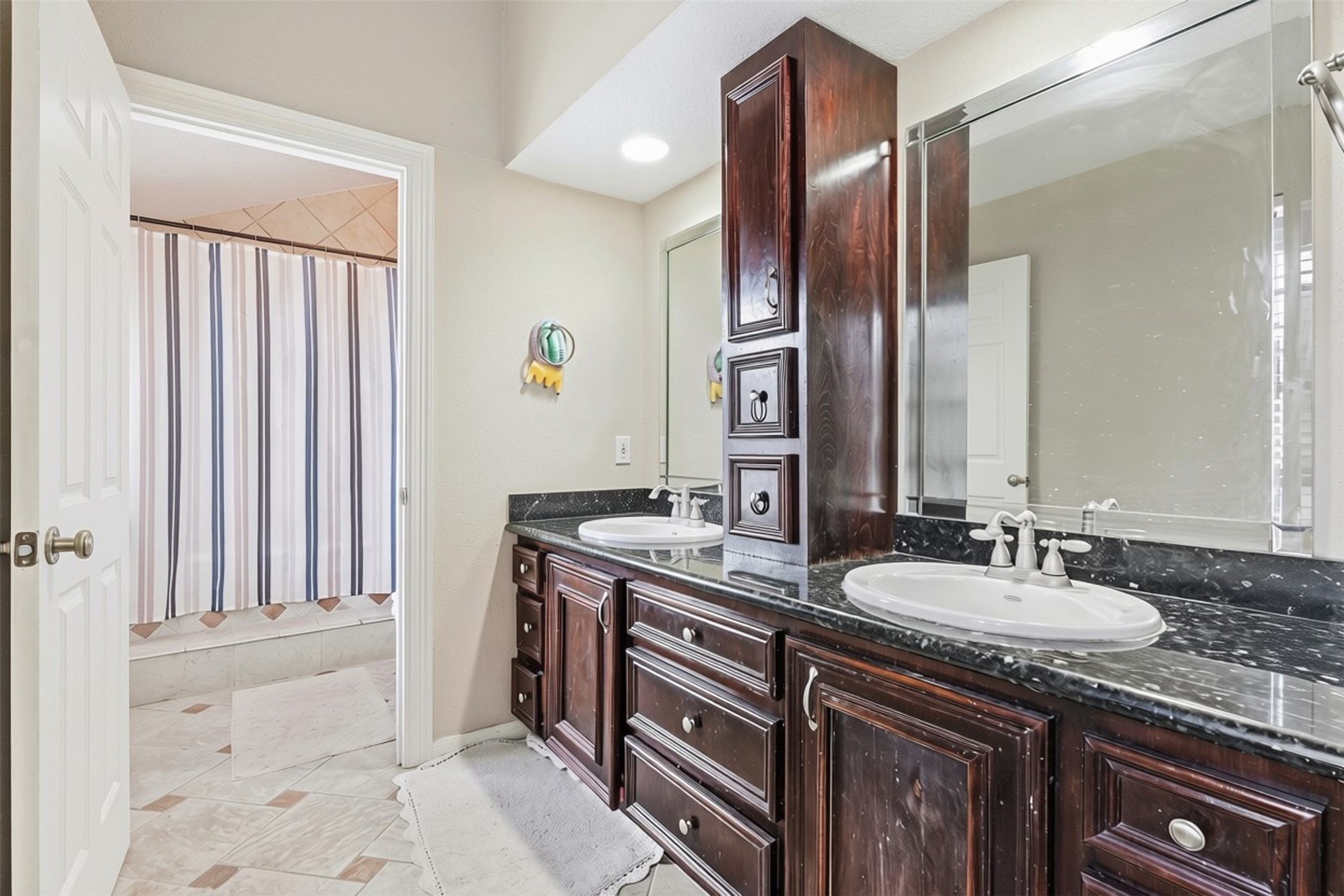 25539 Chapel Ridge Lane Spring, TX 77373 - Photo 16 of 40 Spacious primary bathroom featuring dual sinks, dark wood cabinetry with plenty of storage, and a sleek black countertop.