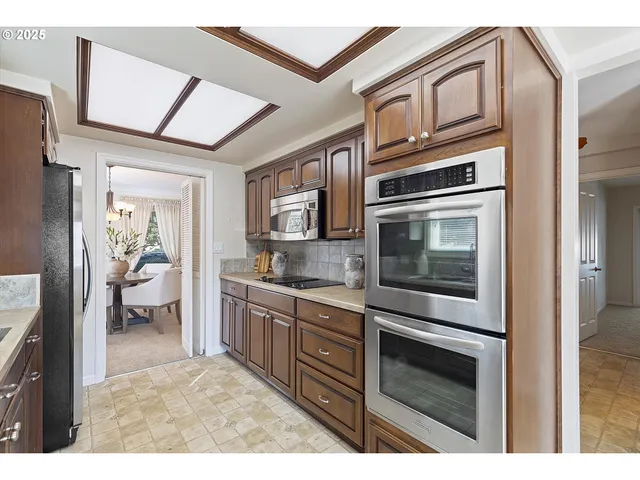 a kitchen with stainless steel appliances granite countertop a stove top oven a sink and dishwasher